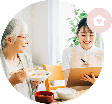 食事の様子を記録するスタッフと利用者